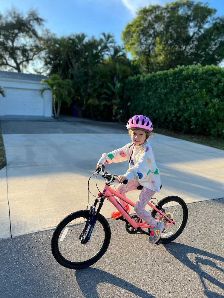 One of the kids riding her bike up the driveway on a bright Lee County afternoon.