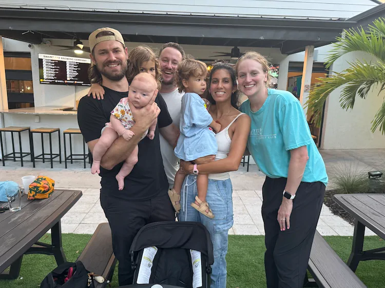 Elliot with his family and friends on the patio of a Lee County brewery, a baby in his arms.